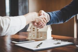 Real estate agent and customers shaking hands together celebrati